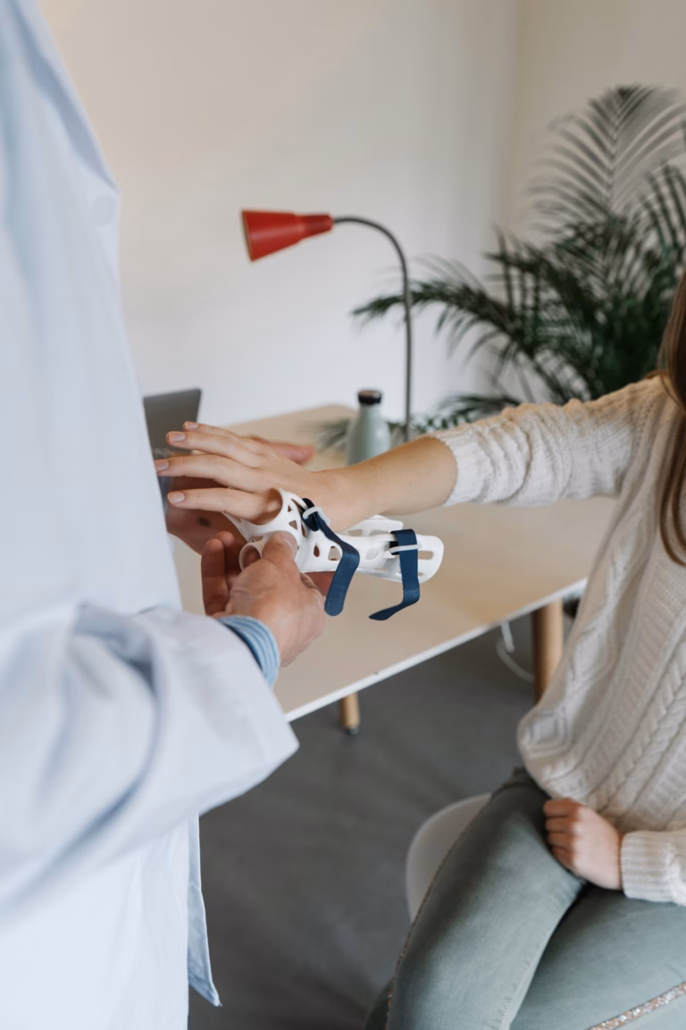 A clinician fitting a wrist support for a patient